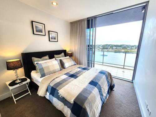 ブリスベンにあるSpacious River View Escape with Free Secure Park - 2BR, 2BA and Sofa Bedのベッドがあり水辺の景色が見える寝室