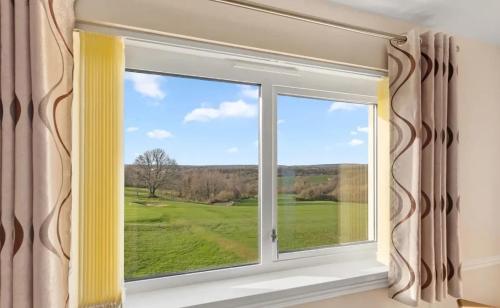 a window with a view of a golf course at Fairways View at Haverfordwest Golf Club in Haverfordwest