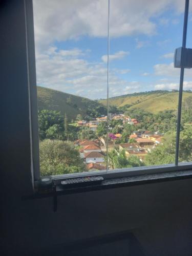 a window with a view of a town at Linda suíte confortável e com linda vista 101 in Conservatória