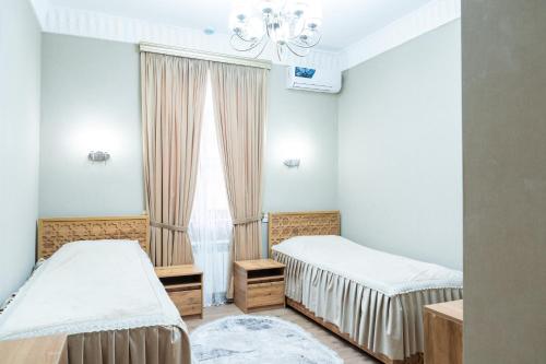 a bedroom with two beds and a window at Hotel Caravan Serail in Samarkand