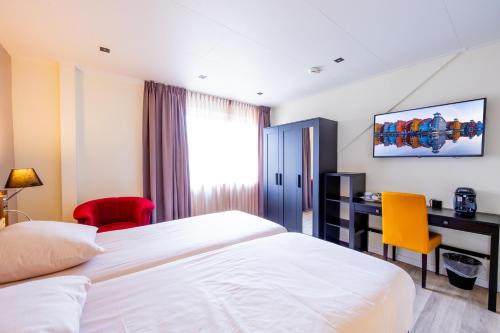 a hotel room with a bed and a desk at Best Western Plus Hotel Restaurant Aduard in Aduard