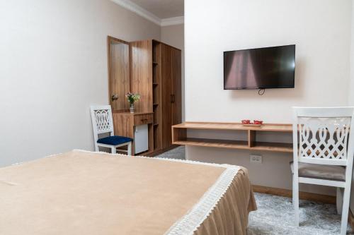 a bedroom with a bed and a tv on a wall at Hotel Caravan Serail in Samarkand