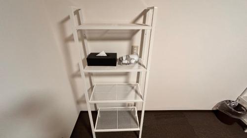 a white book shelf with a box on it at Slopeside Lodge Hakuba in Otari