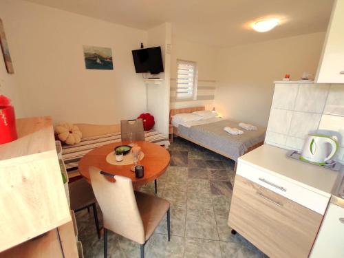 Una cocina con una mesa y una habitación con una cama. en Apartments Boa, en Slatine
