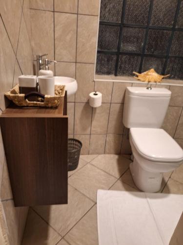 a bathroom with a toilet and a sink at Escape to Tranquility ! in Kiserian