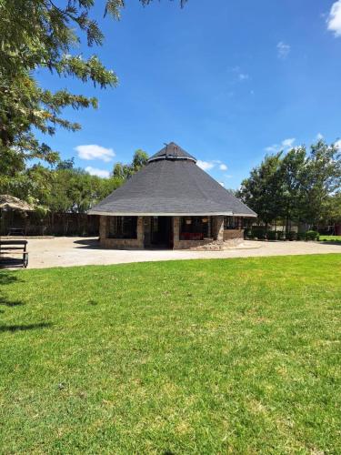 a large building with a black roof in a park at Escape to Tranquility ! in Kiserian