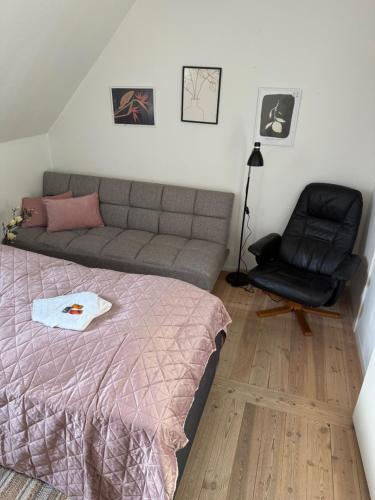 a bedroom with a bed and a couch and a chair at Meget central, fri parkering, 4-7 personers overnatningssted in Herning