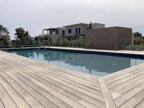 une piscine avec une terrasse en bois et une maison dans l'établissement tianau, à Lecci