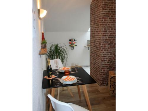 a dining room with a table and a brick wall at Wohnlust 3 in Malchow