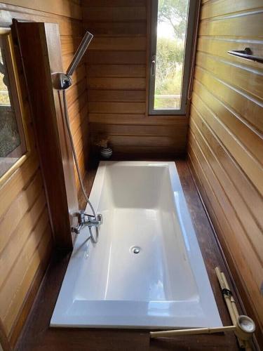 - un lavabo blanc dans une petite salle de bains avec fenêtre dans l'établissement meiji, à Pinarellu