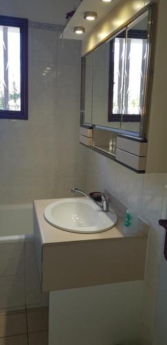 une salle de bain avec un lavabo et un miroir dans l'établissement Maison, grand jardin, lac 8 min à pied, piste cyclable, 6 couchages, à Sévrier