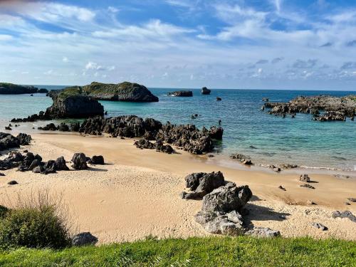 a beach with rocks in the water and the ocean at Secret Paradise, Stylish Host in Camargo