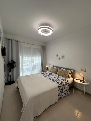 a white bedroom with a bed and a window at Hernando II in Calpe