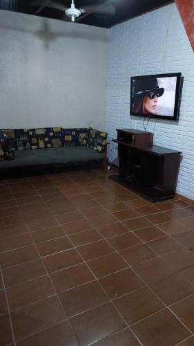 卡拉瓜塔图巴Casa com Piscina em Caraguatatuba的一间配有沙发的房间和墙上的电视