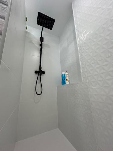 a white bathroom with a shower with a black shower head at Hernando II in Calpe