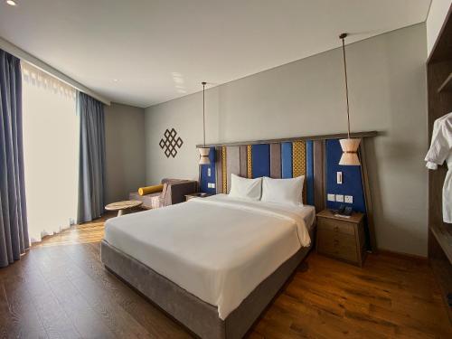ein Schlafzimmer mit einem großen weißen Bett in einem Zimmer in der Unterkunft Apec Mandala Ocean Retreat - Mui Ne in Mui Ne