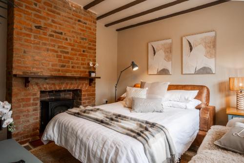 un lit dans une chambre avec un mur de briques dans l'établissement Jasmine Cottage, à Skipsea