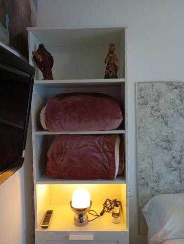 a white book shelf with a light in a bedroom at Calderón Playa in Gijón