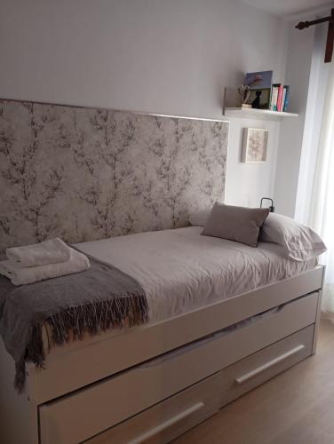 a bed in a bedroom with a wall at Calderón Playa in Gijón