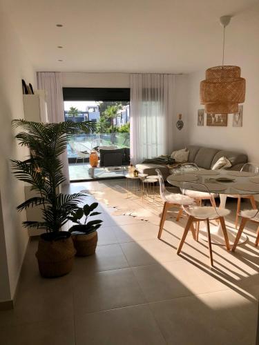 a living room with a table and a couch at Casa Noyas Oasis Beach in Guardamar del Segura