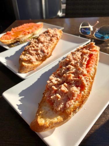 two slices of pizza on a white plate on a table at Casa Noyas Oasis Beach in Guardamar del Segura