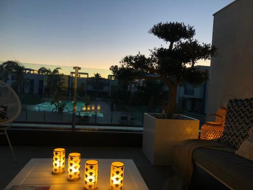 a room with a table with candles on a balcony at Casa Noyas Oasis Beach in Guardamar del Segura