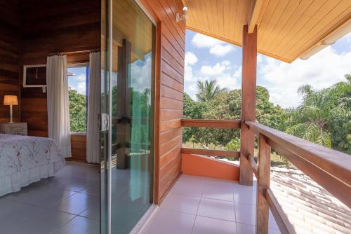 a room with a balcony with a bed and a window at Fazenda Góes in Conde
