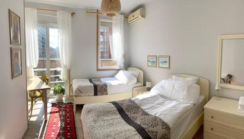 a bedroom with two beds and a window at Capital Apartment Tirana in Tirana