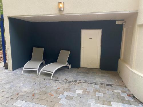 two chairs sitting in front of a blue wall at duplex romantique in Clavier