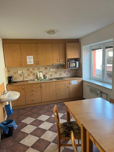 a kitchen with wooden cabinets and a wooden table at Ubytování Sedmička in Dolní Rožínka