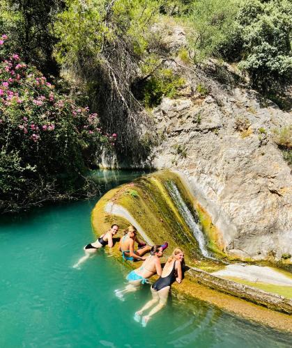 a group of people sitting in the water near a waterfall at Casa Noyas Oasis Beach in Guardamar del Segura