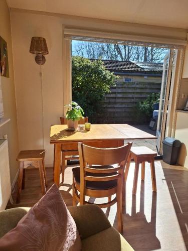 a living room with a table and chairs and a window at Rekerlanden 257 in Schoorldam