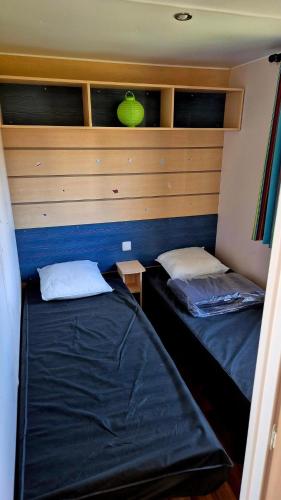 - 2 lits dans une petite chambre aux murs bleus dans l'établissement Bungalow 6 pers. près du puy du fou, à La Boissière-de-Montaigu