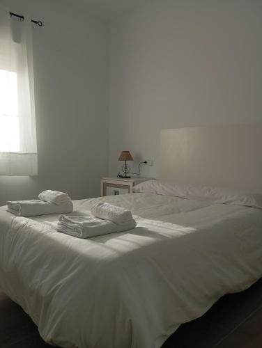 a white bed with two towels on top of it at La Olmeda del Maripinar in Cieza