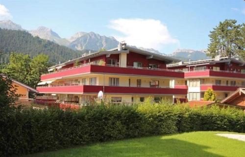 a large building with mountains in the background at Apart 13 by Alpenidyll Apartments in Schladming