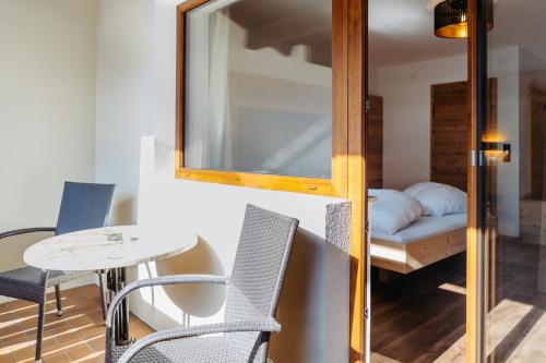 a room with a table and chairs and a bed at Hotel Klockerhof in Lermoos