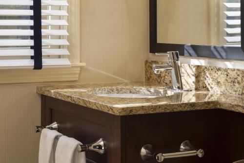 a bathroom with a sink and a mirror at Ocean Mist Hotel in Yarmouth