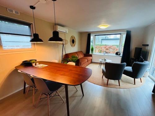 a living room with a wooden table and chairs at Nature Escape Veluwe Chalet in Putten