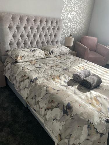 a bedroom with a large bed with a large headboard at Aldam House in Darlington