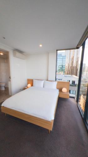 a bedroom with a large bed and large windows at Ultimate Southbank Getaway with Free Parking in Melbourne