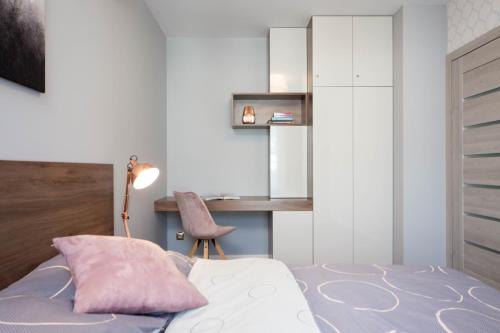 a bedroom with a bed with a desk and a chair at Apartamenty w centrum Krakowa nad Wisłą in Kraków