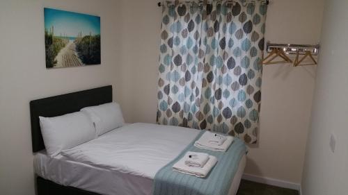 オックスフォードにあるザ オックスフォード ハウスの小さなベッドルーム(ベッド1台、タオル2枚付)