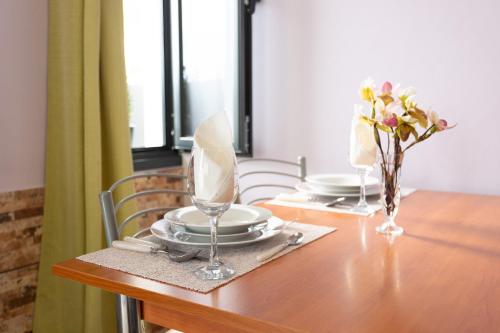 a dining room table with plates and a vase of flowers at Village Center One Bedroom Apartment in Porto Moniz