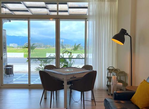 a dining room with a table and chairs and a large window at 根本町無印風Villa包棟寵物友善 朋友聚會 烤肉廚房 兒童友善 in Yilan City