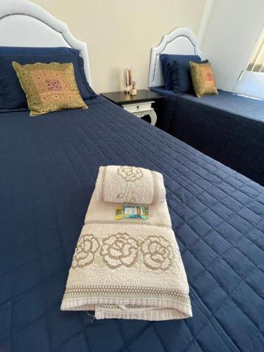 a bedroom with a blue bed with a white bedspread at Apartamento Vista da Serra in Poços de Caldas