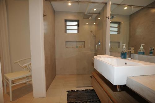 a bathroom with a white sink and a shower at Beachfront & Pool Poste Lafayette in Poste Lafayette