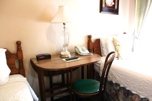 a bedroom with a table with a lamp and a bed at The Inn On Third in St. Petersburg