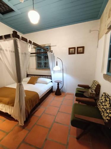 a bedroom with a bed and a chair in a room at 八八金歐王金城洋樓古厝民宿 in Jinsha