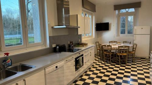 a kitchen with a table and a kitchen with white appliances at Le Manoir de Conteville in Paluel