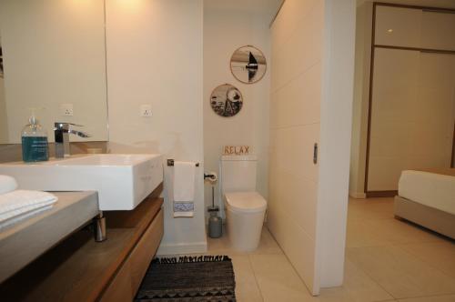 a bathroom with a sink and a toilet at Beachfront & Pool Poste Lafayette in Poste Lafayette